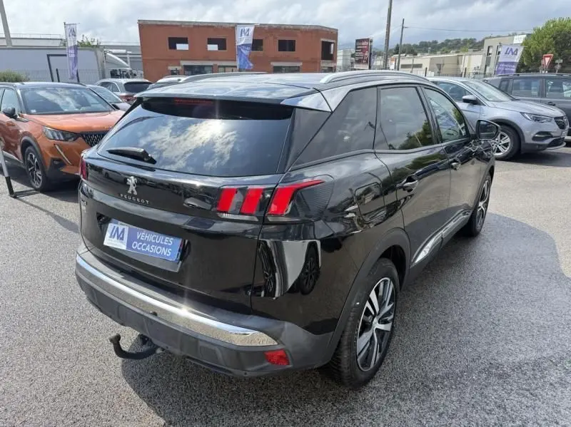 Vue 3/4 arrière droite d'un Peugeot 3008 noir 2018 avec feux arrière distinctifs et attelage visible sur parking.