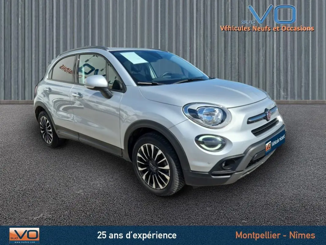Fiat 500X gris clair vue 3/4 avant droit, jantes alliage 17 pouces et phares à LED visibles.