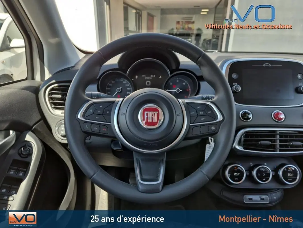 Vue intérieure du volant multifonction et tableau de bord du Fiat 500X gris clair, version 2022 Cross diesel.