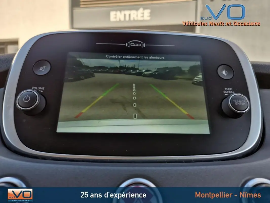 Écran central de la Fiat 500X gris clair montrant la caméra de recul avec guidage de trajectoire coloré.