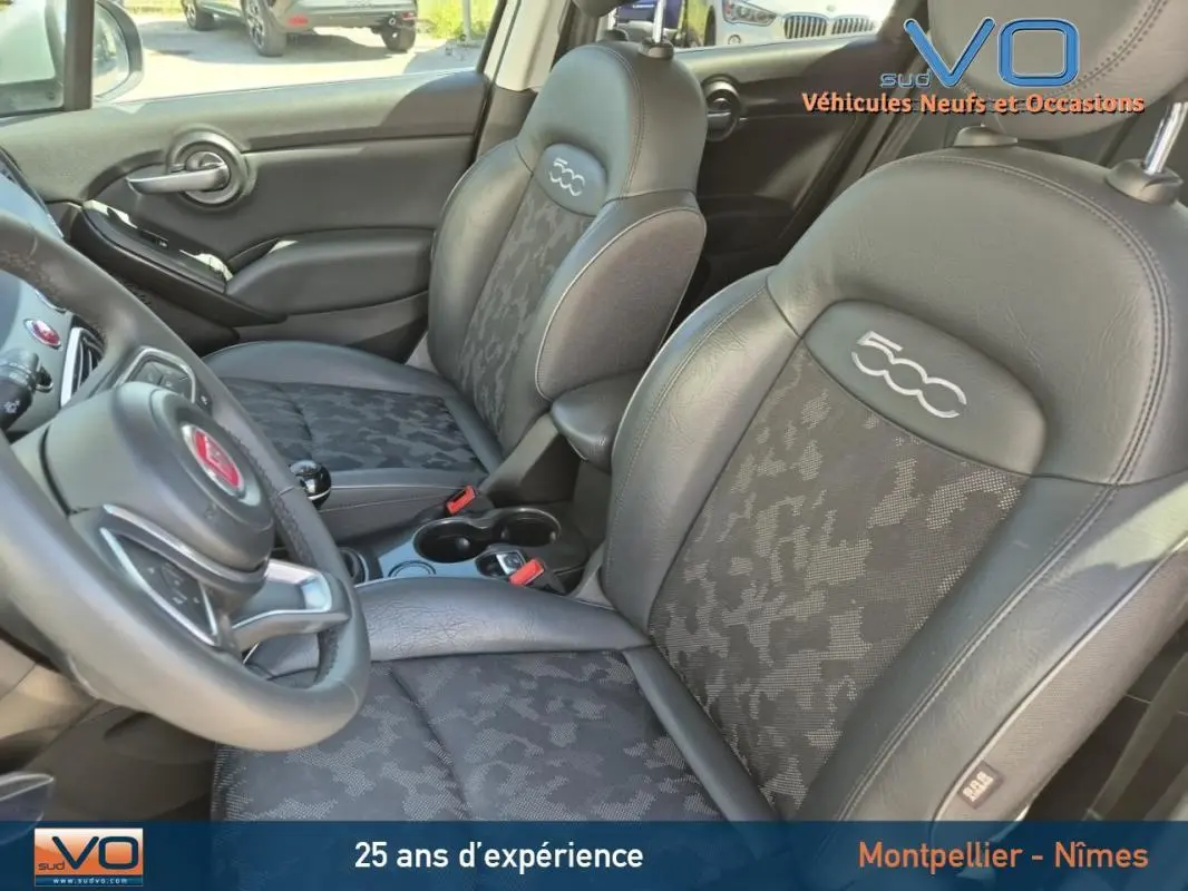 Vue intérieure rapprochée des sièges avant noirs avec logo 500 brodé sur une Fiat 500X gris clair.