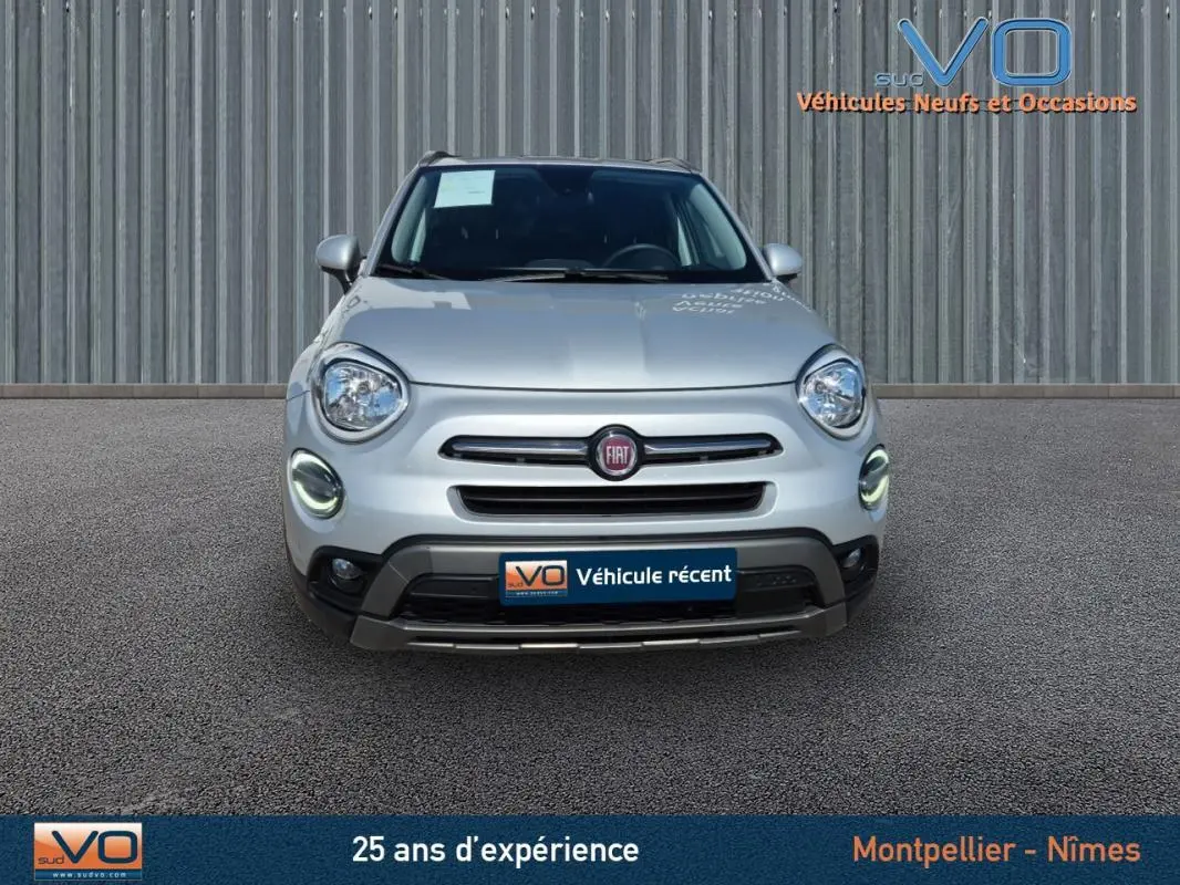 Vue frontale d'un FIAT 500X gris clair avec phares LED et calandre distinctive, sur fond neutre extérieur.