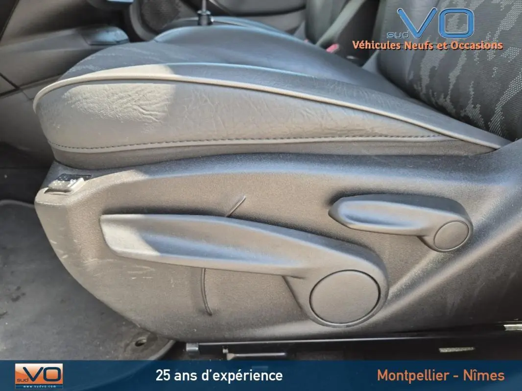 Gros plan sur la manette de réglage en hauteur du siège conducteur noir du Fiat 500X gris clair modèle 2022.