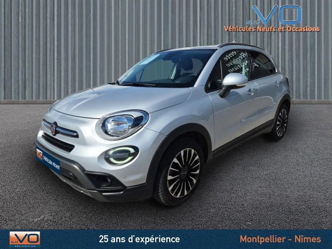 Vue 3/4 avant d'une FIAT 500X MY21 gris clair avec jantes alliage 17 pouces et phares à LED allumés.
