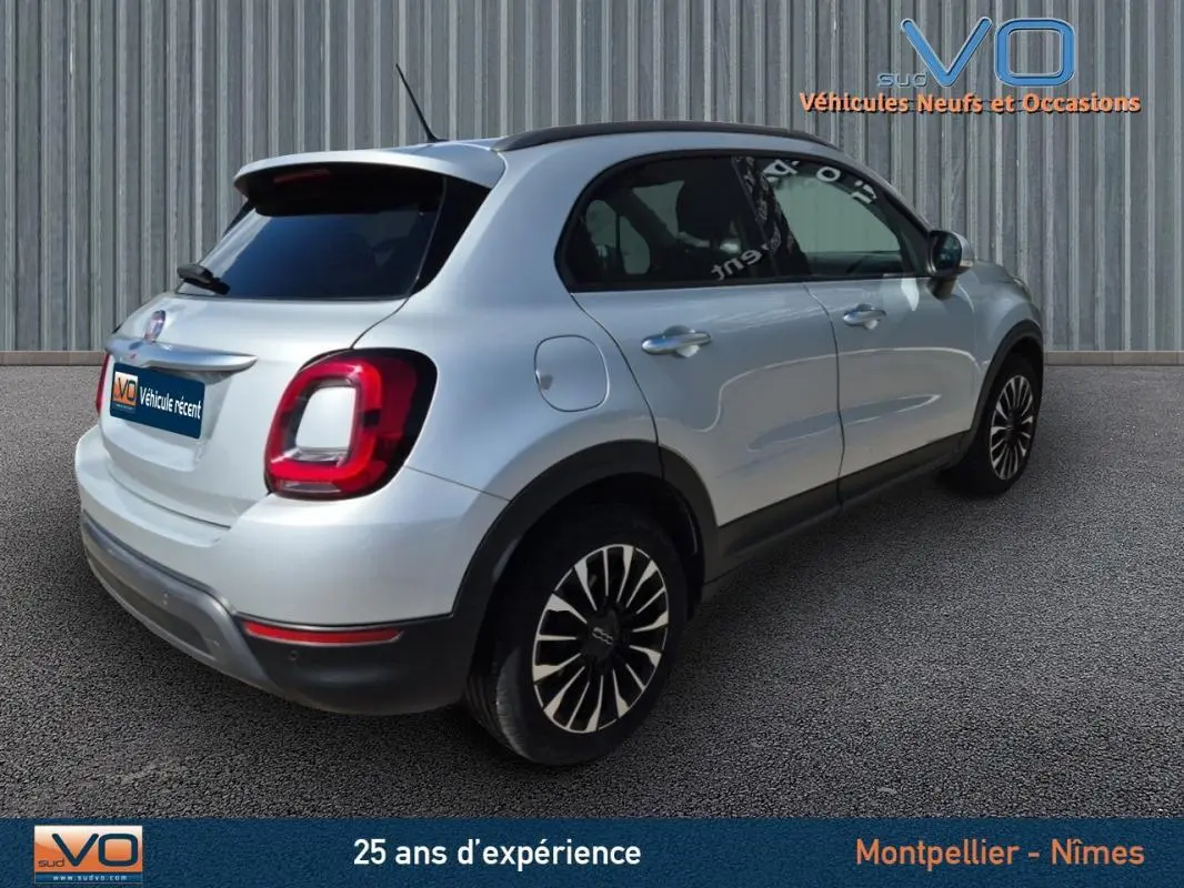 Vue 3/4 arrière droite d'un FIAT 500X gris clair avec jantes alliage 17 pouces sur fond neutre.