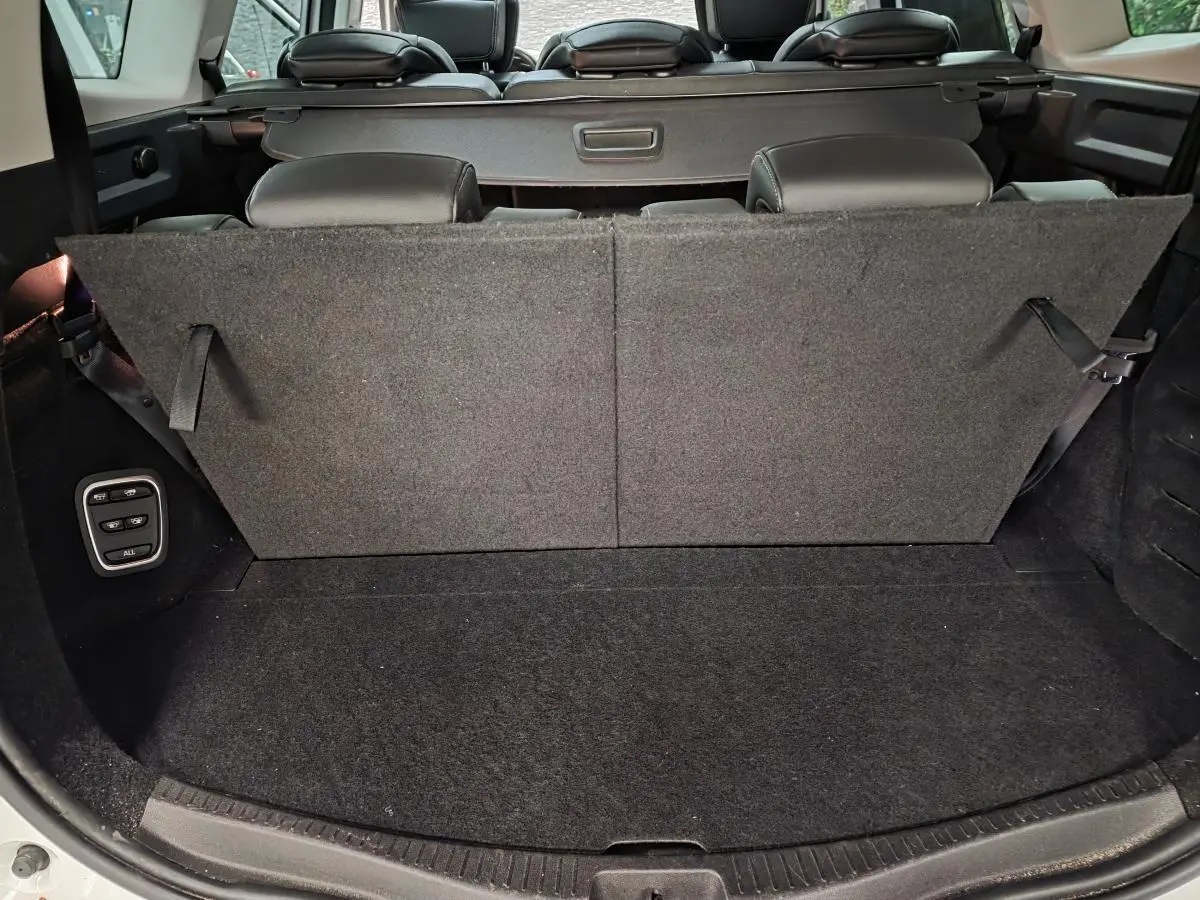 Coffre arrière du Renault Scénic blanc 2017 avec banquette rabattue et commandes électriques côté gauche.