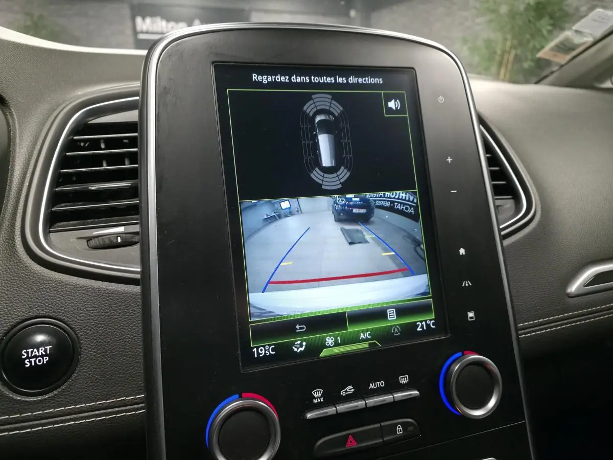 Écran tactile central du Renault Scénic blanc 2017 montrant la caméra de recul et les commandes de climatisation.