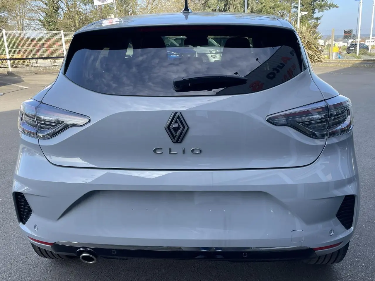 Vue arrière d'une Renault Clio Gris Rafale 2025 avec feux LED et sortie d'échappement chromée visible.
