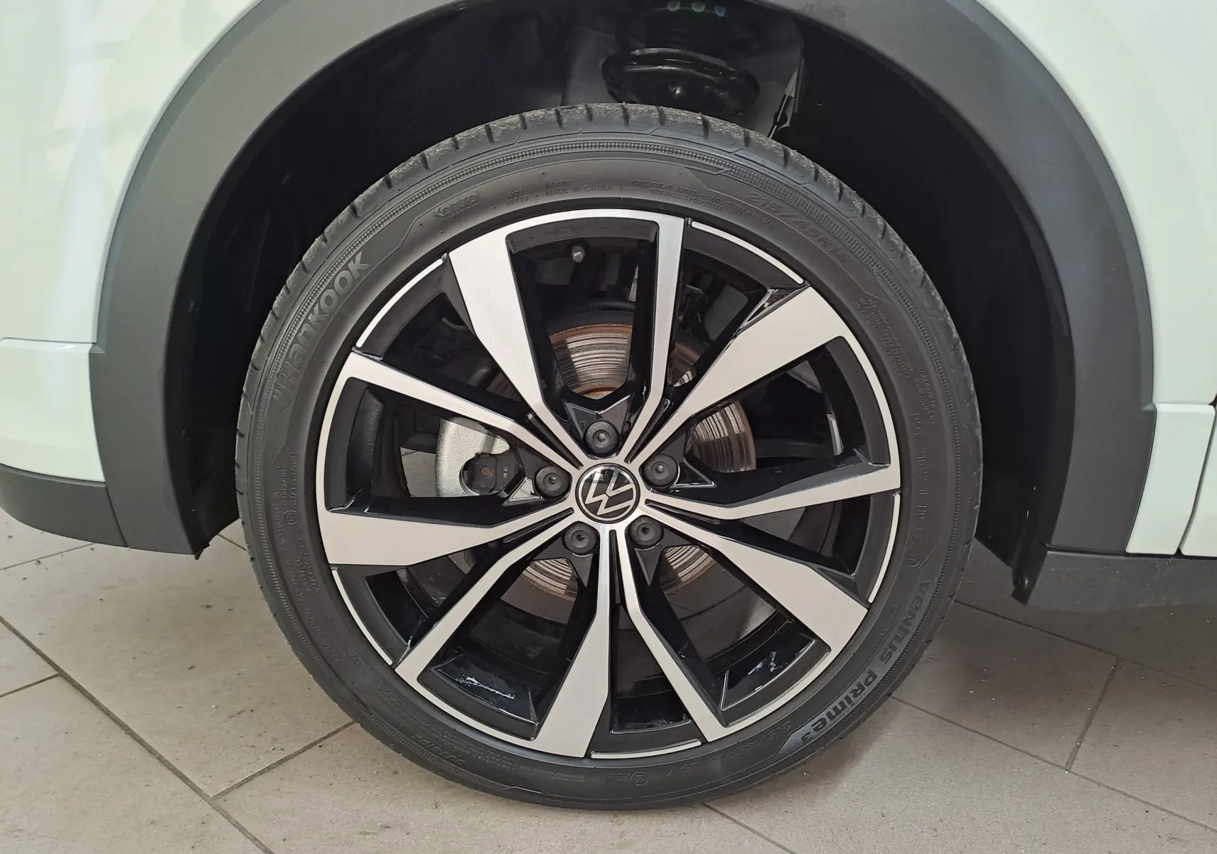 Vue 3/4 arrière droite du Volkswagen T-Cross blanc pur 2025 avec feux LED distinctifs et jantes alliage R-Line.