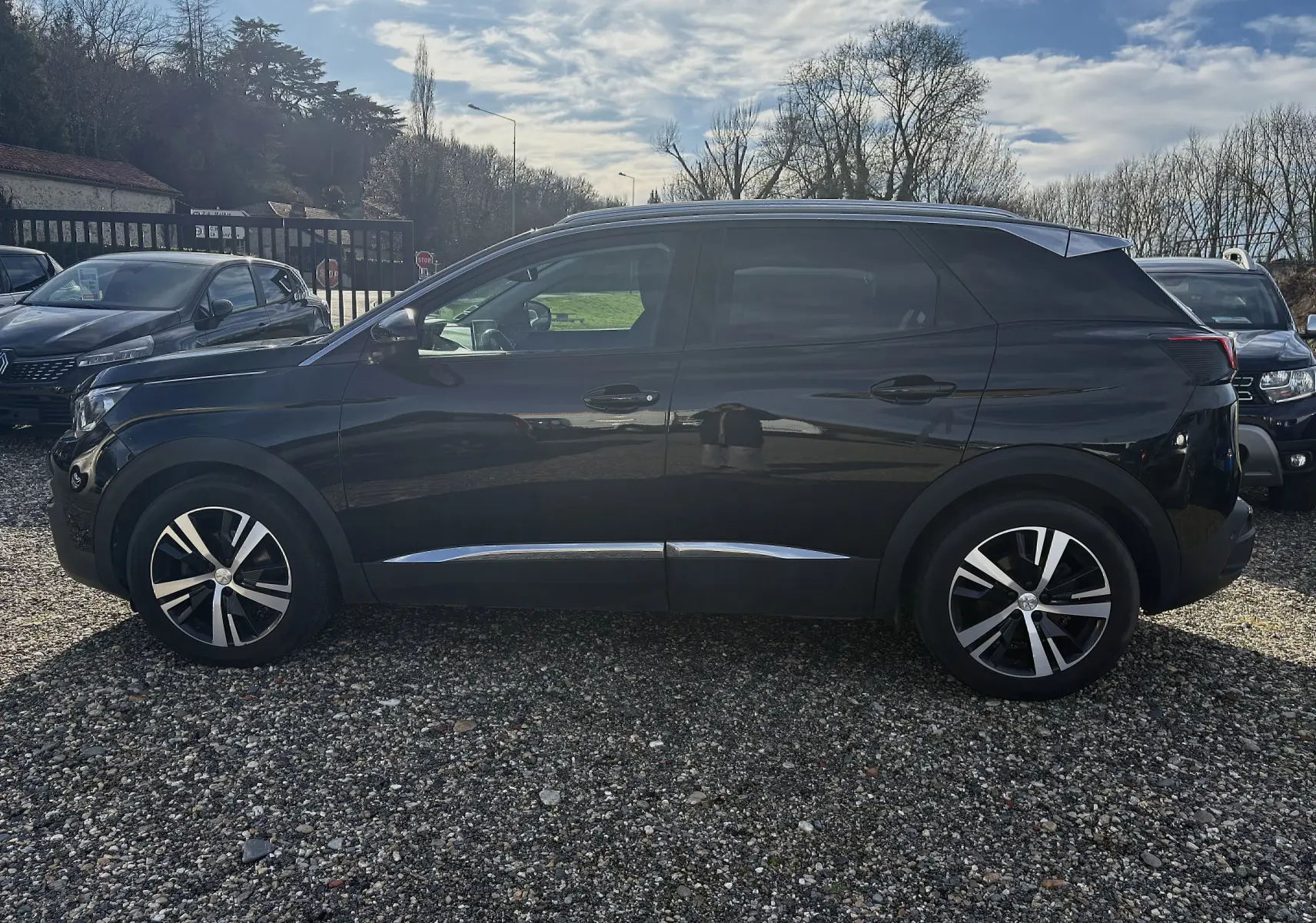 Vue de profil côté gauche d'un Peugeot 3008 noir de 2019 avec jantes alliage et détails chromés sur le bas de caisse.