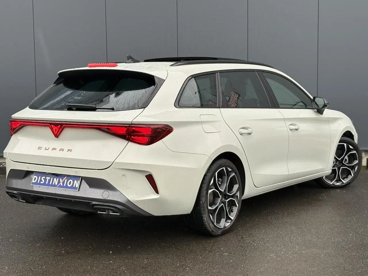 Vue 3/4 arrière droite de la CUPRA Leon ST gris Taiga avec jantes alliage 18'' et toit ouvrant panoramique.