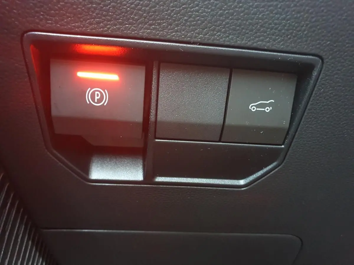 Boutons de commande du frein de parking électrique et ouverture du coffre sur tableau de bord noir du Dacia Bigster.