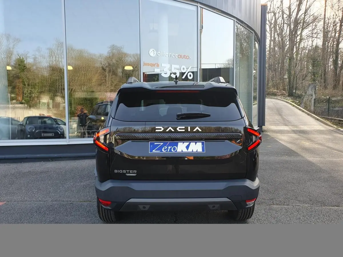 Vue arrière du Dacia Bigster noir Perla avec signature lumineuse LED et toit panoramique visible.