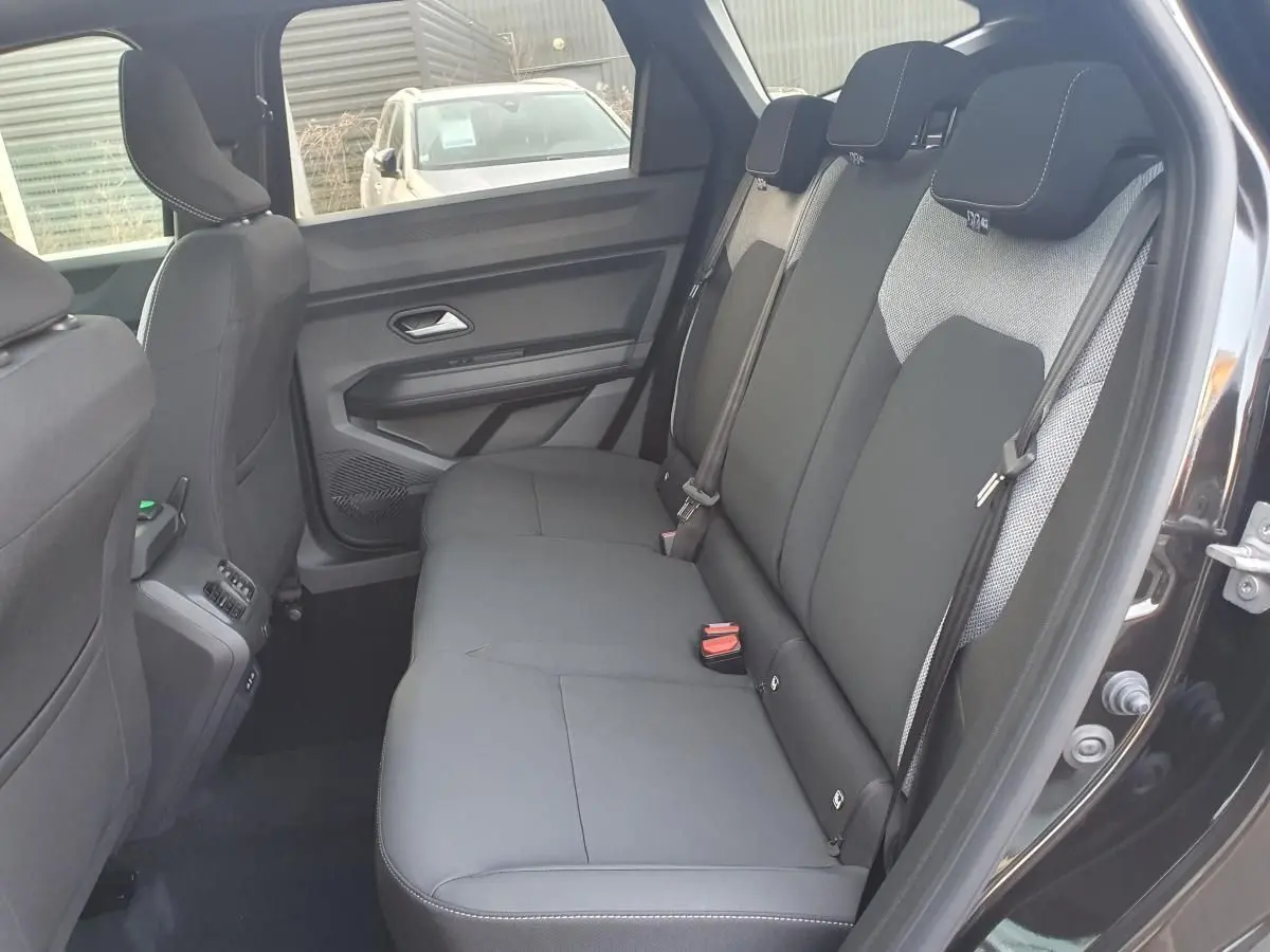 Vue intérieure côté droit sur la banquette arrière noire du Dacia Bigster 2026 avec porte ouverte et ceinture visible.