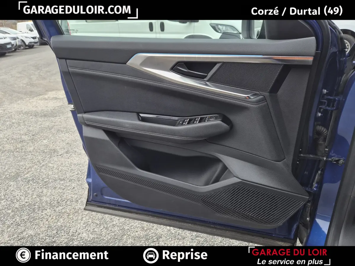 Vue rapprochée de la porte avant gauche bleu foncé du Renault Austral avec garniture noire et inserts métalliques.