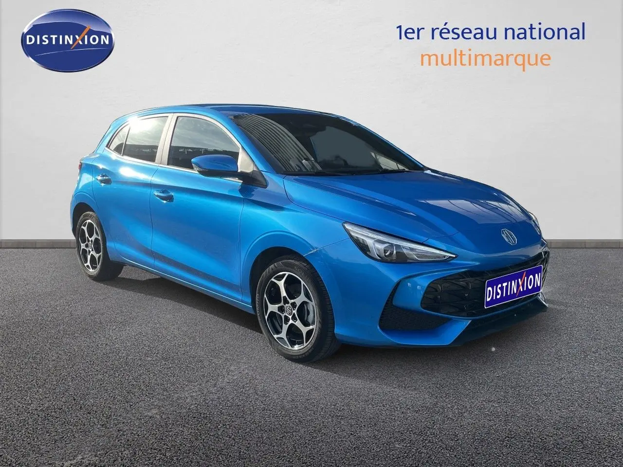 Vue 3/4 avant d'une MG3 2025 hybride en bleu métallisé, avec jantes alliage et calandre noire distinctive.