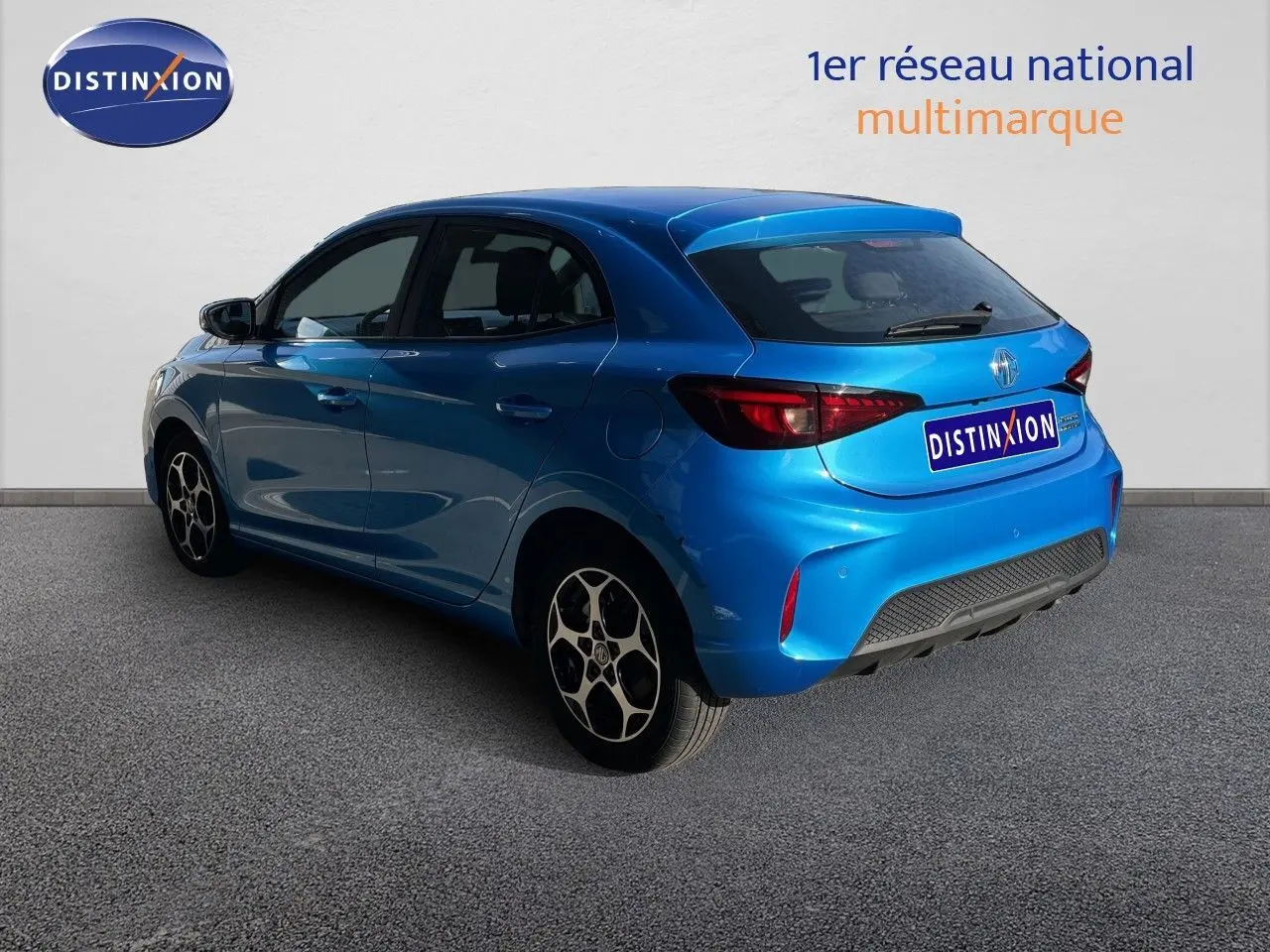 Vue 3/4 arrière droite d'une MG3 1.5L HYBRID+ 195CH en bleu Como Metal avec jantes distinctives et feux arrière LED.
