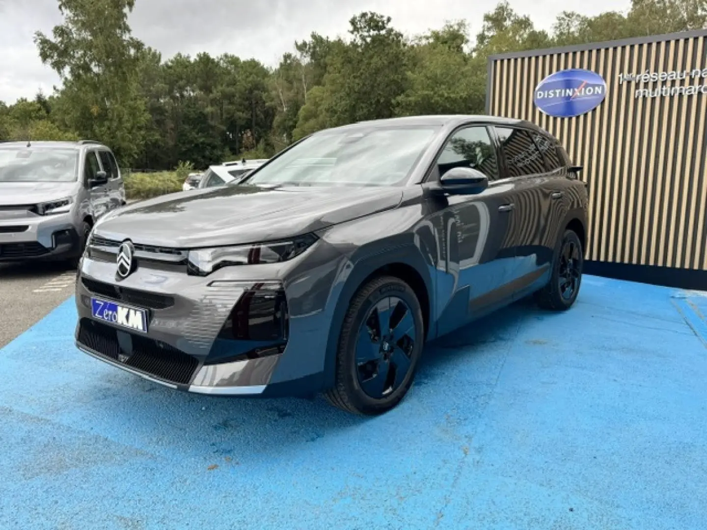 Citroën C5 Aircross gris Platinium vue 3/4 avant droit, jantes noires et calandre moderne distinctive.