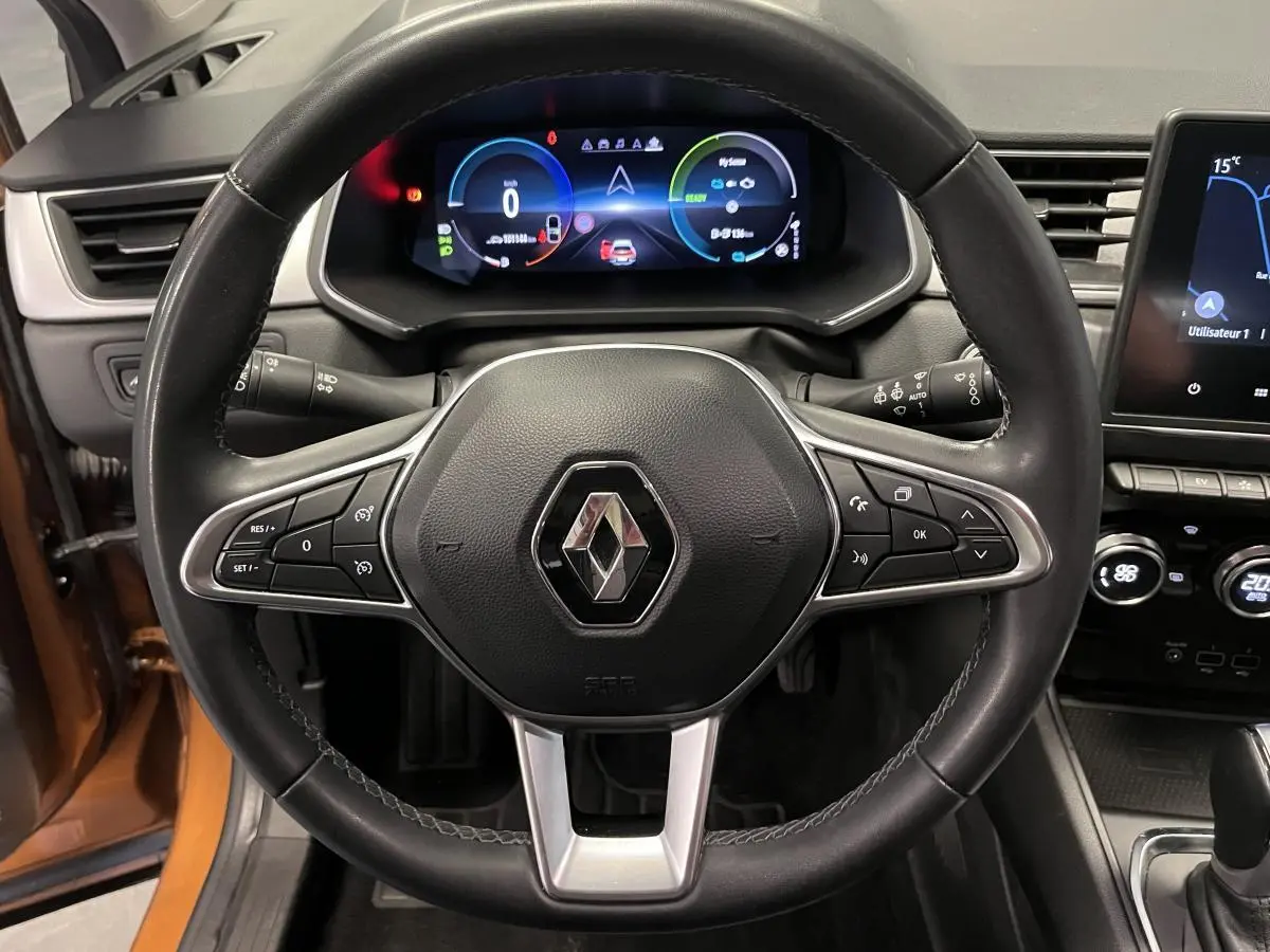 Vue intérieure centrée sur le volant cuir noir du Renault Captur 1.6 E-Tech avec tableau de bord numérique coloré.