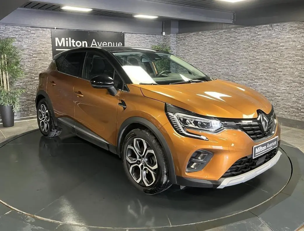 Renault Captur 1.6 E-Tech Hybride rechargeable orange vue 3/4 avant avec toit noir et jantes alliage 18 pouces.