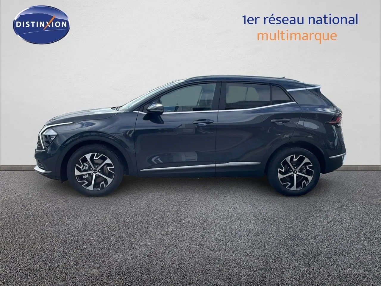 Profil côté gauche d'un Kia Sportage gris foncé métal 2025 avec jantes alliage bicolores et lignes modernes.