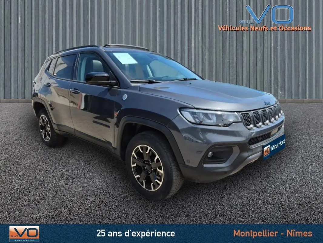 Jeep Compass Trailhawk gris foncé en 3/4 avant droit, mettant en valeur ses jantes spécifiques et sa calandre distinctive.