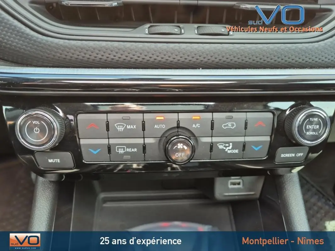 Tableau de bord du Jeep Compass gris foncé 2022, vue rapprochée des commandes climatisation et audio.