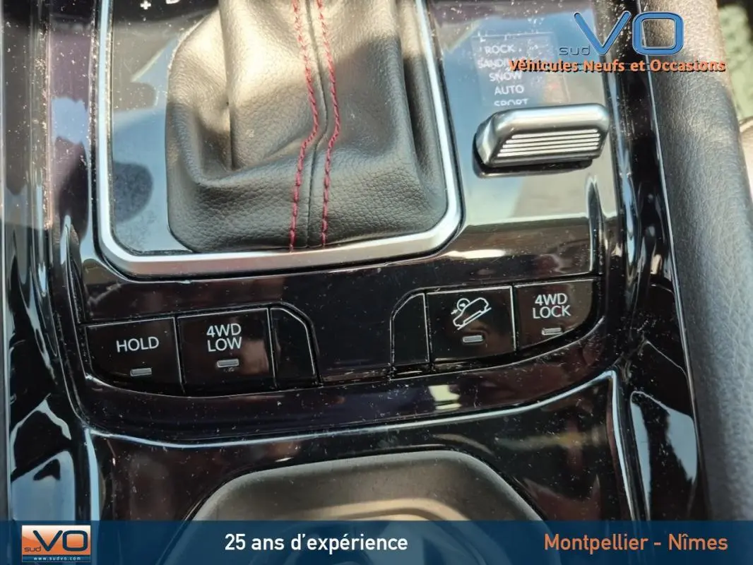 Gros plan sur la console centrale noire du Jeep Compass Trailhawk 2022, mettant en valeur les commandes 4WD et la boîte auto.