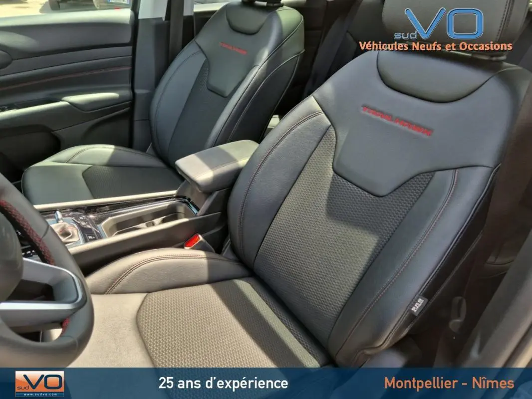 Intérieur du Jeep Compass 2022 gris foncé, vue sur sièges avant en cuir avec surpiqûres rouges Trailhawk.