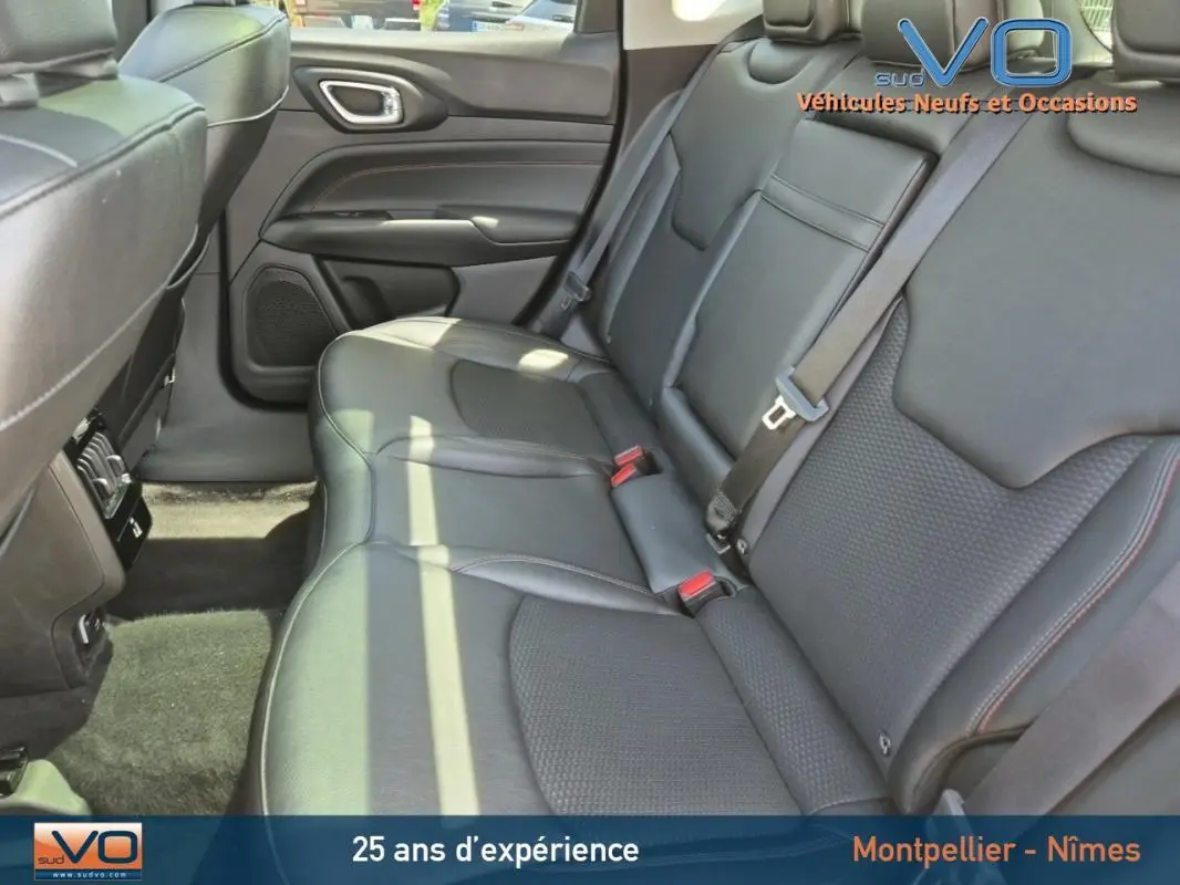 Vue intérieure des sièges arrière en cuir noir du Jeep Compass 2022, version hybride Trailhawk, avec ceintures de sécurité visibles.