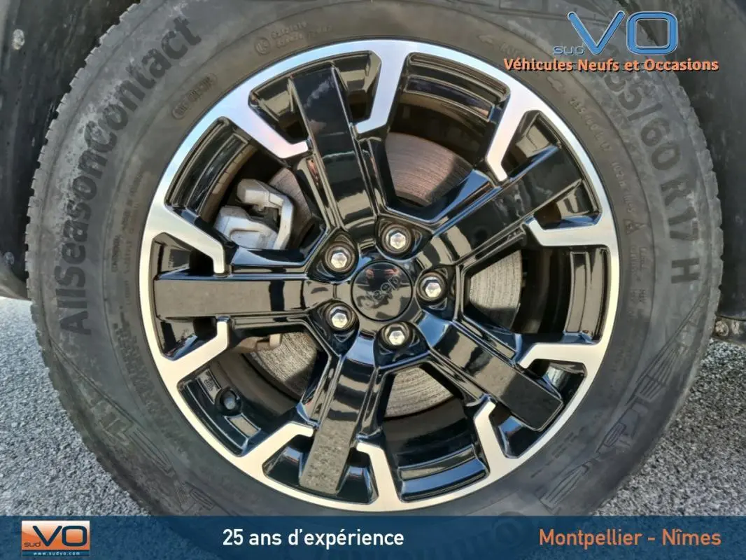 Gros plan sur la jante noire brillante et polie du Jeep Compass Trailhawk 2022, pneu AllSeasonContact visible.