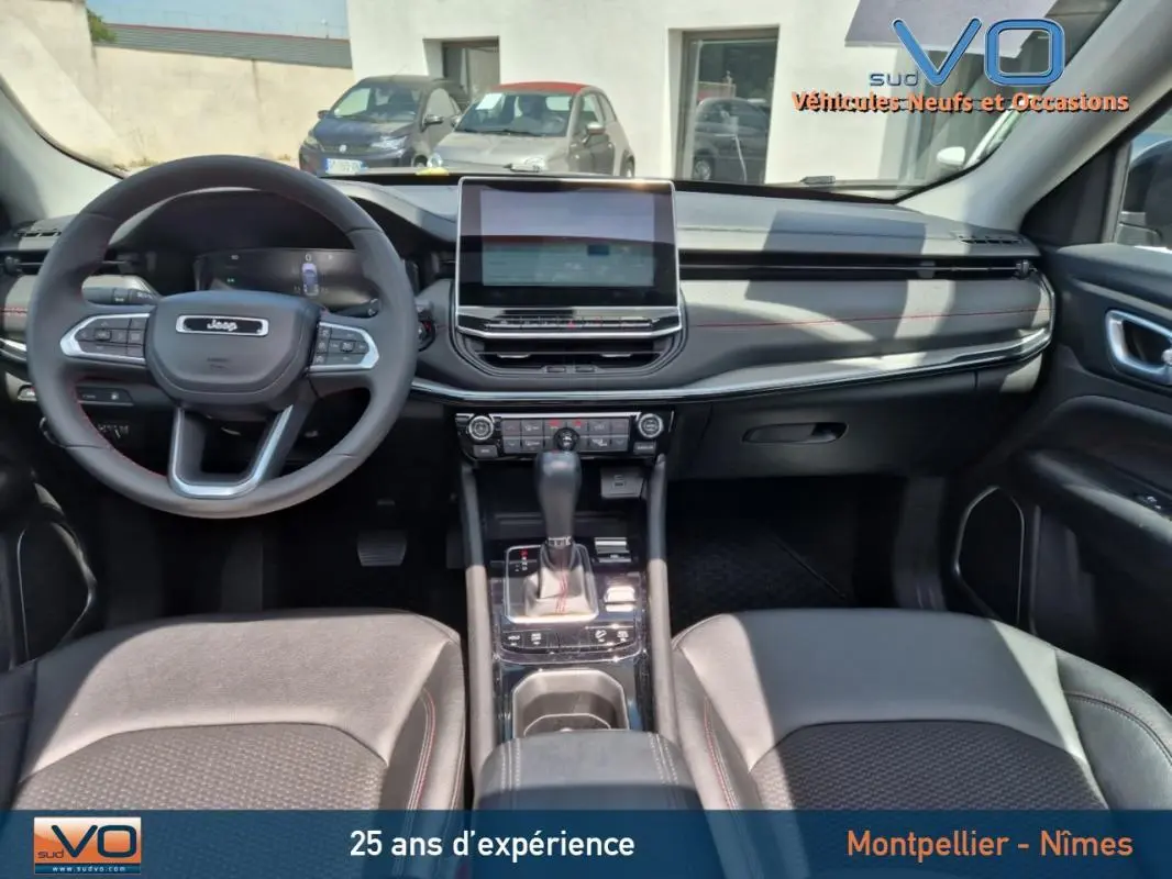 Intérieur du Jeep Compass 2022, vue frontale du tableau de bord avec écran tactile et volant multifonction.