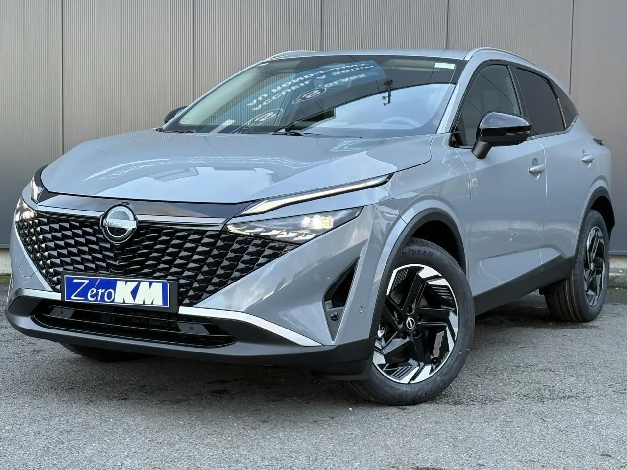 Nissan Qashqai III e-Power gris Ceramic en 3/4 avant droit, avec calandre noire et jantes alliage 18 pouces.