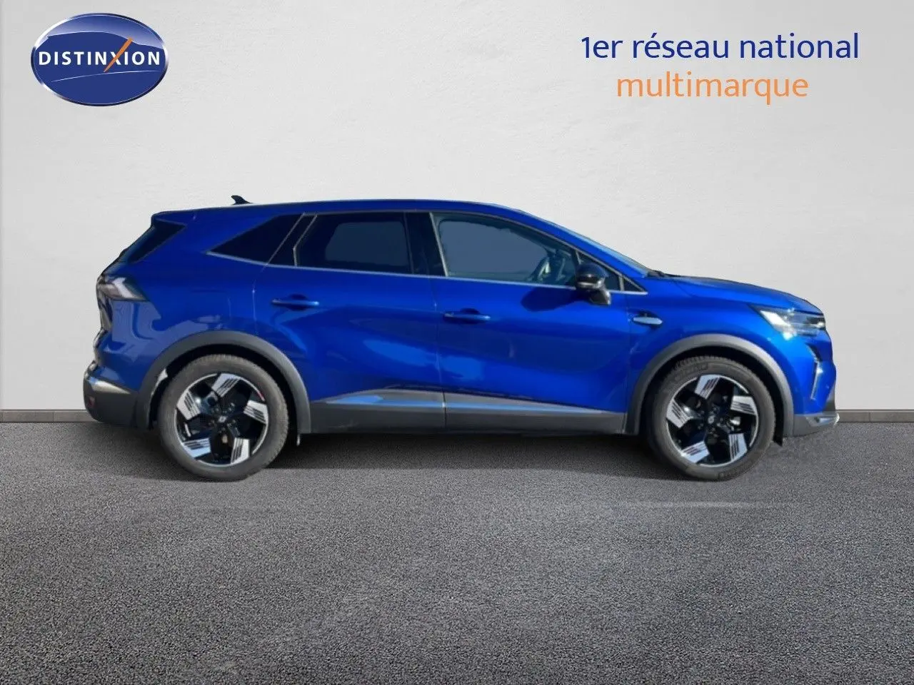 Renault Symbioz 2025 bleu Iron Metal en 3/4 avant droit, avec calandre distinctive et jantes bicolores.
