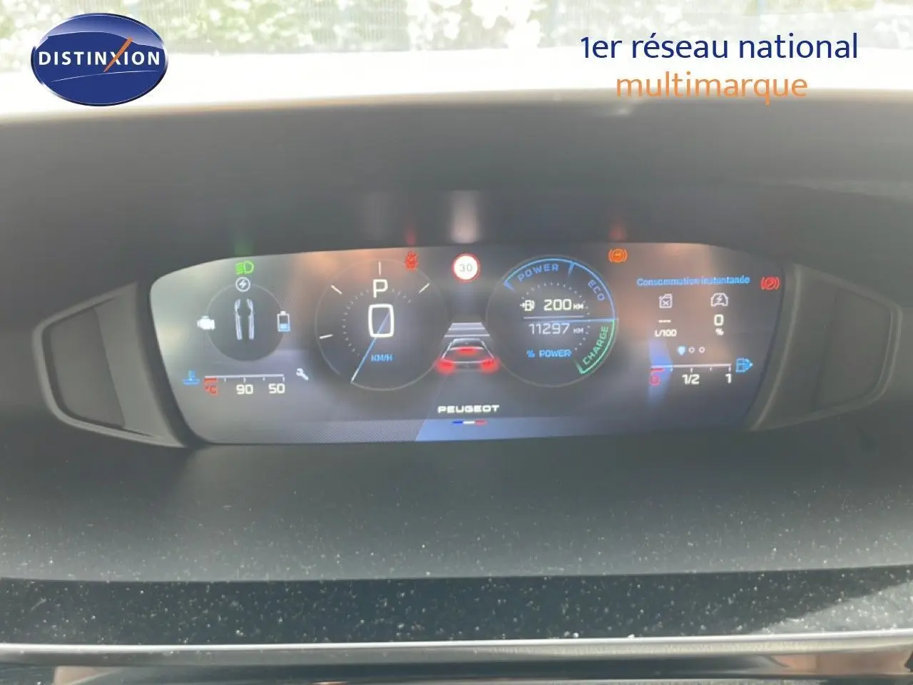Tableau de bord numérique de Peugeot 308 SW Hybrid 2025 affichant la vitesse, autonomie et consommation instantanée.