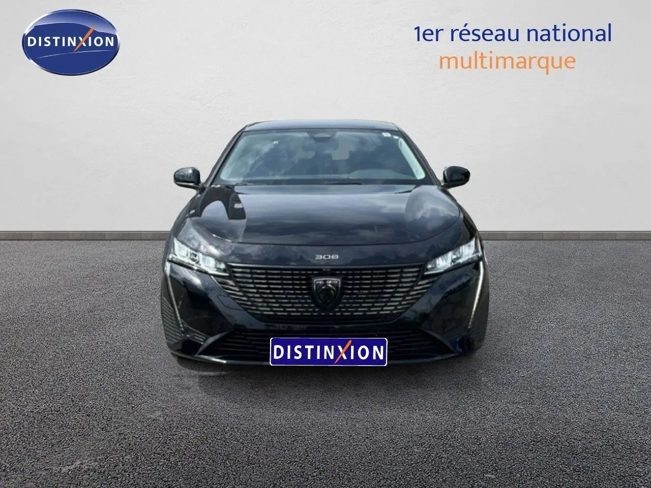 Vue frontale d'une Peugeot 308 SW Hybrid 145ch Allure noire métal avec calandre distinctive et phares LED fins.