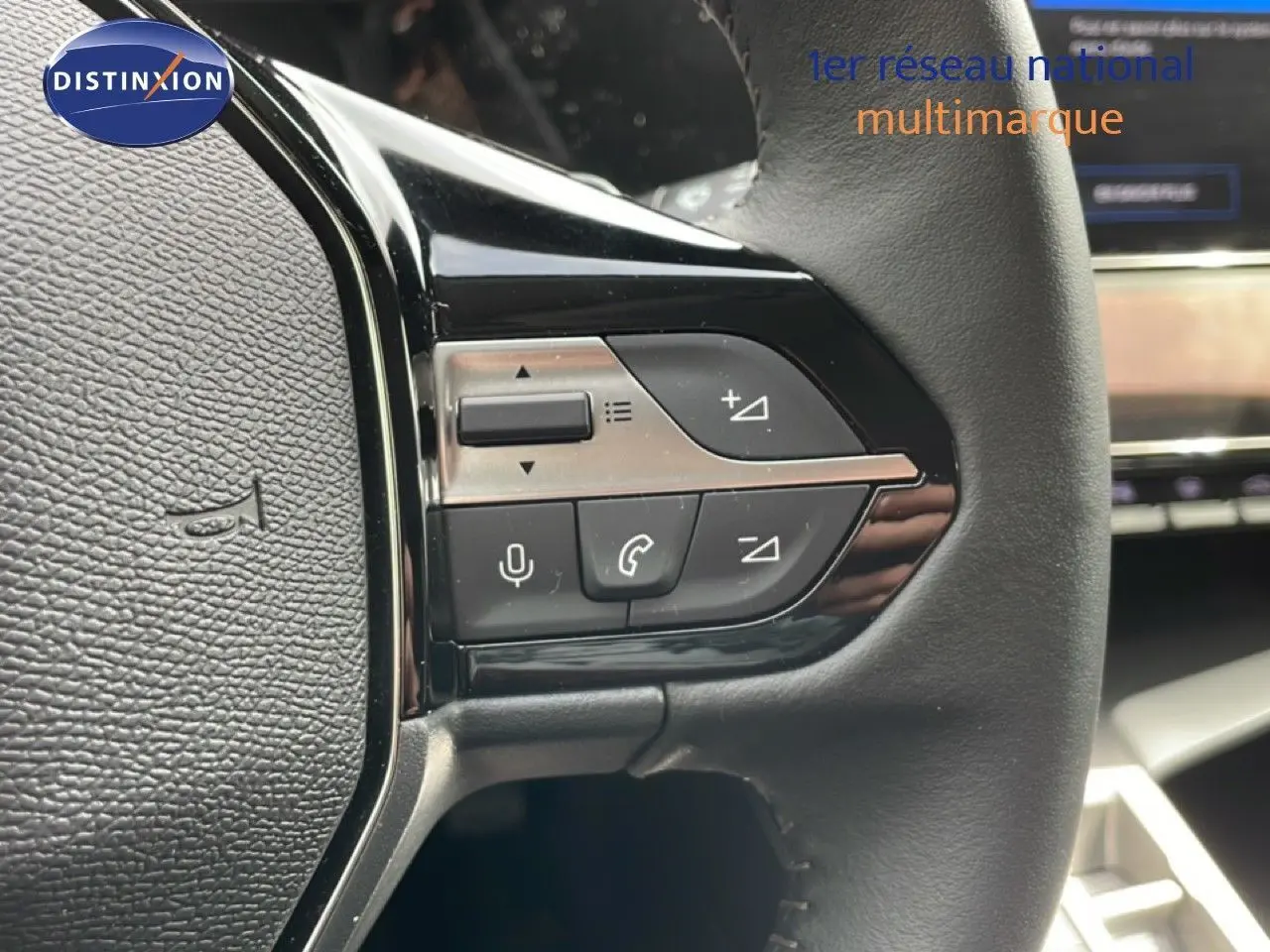 Gros plan sur les commandes multifonctions du volant cuir noir du Peugeot 308 SW Hybrid 2025, finition Allure.