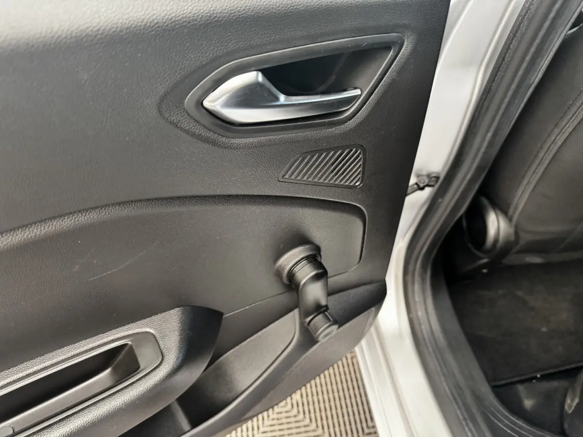 Vue rapprochée de la porte arrière droite gris clair de la Renault Clio Business E-TECH 140 avec manivelle de vitre manuelle.