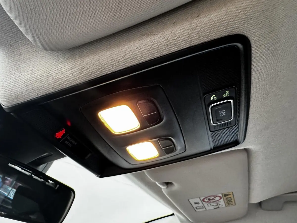 Plafonnier intérieur allumé avec commandes SOS et éclairage, vue du toit d'une Renault Clio Business E-TECH gris clair.