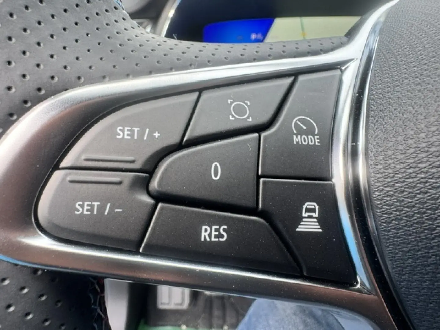Gros plan sur les commandes noires du volant multifonction du Renault Symbioz gris Cassiopée métallisé.