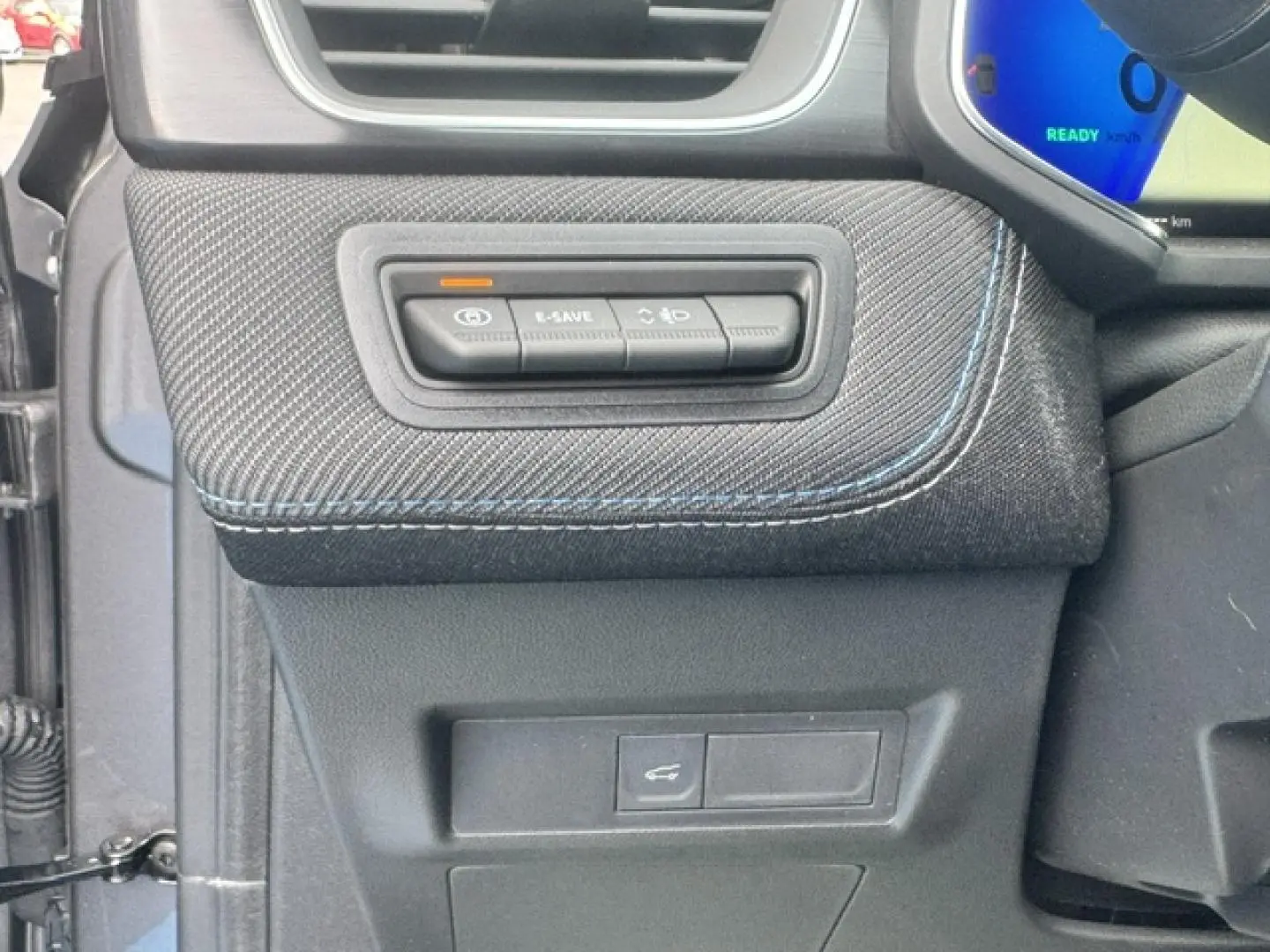 Détail des commandes E-SAVE et éclairage sur la planche de bord côté gauche d’un Renault Symbioz gris Cassiopée.