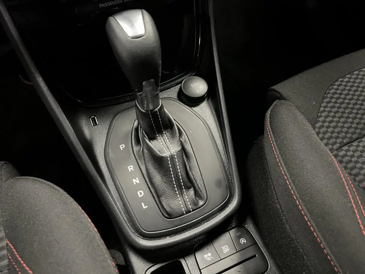 Levier de vitesses automatique noir avec surpiqûres blanches et siège tissu noir à surpiqûres rouges Ford Puma 2023.