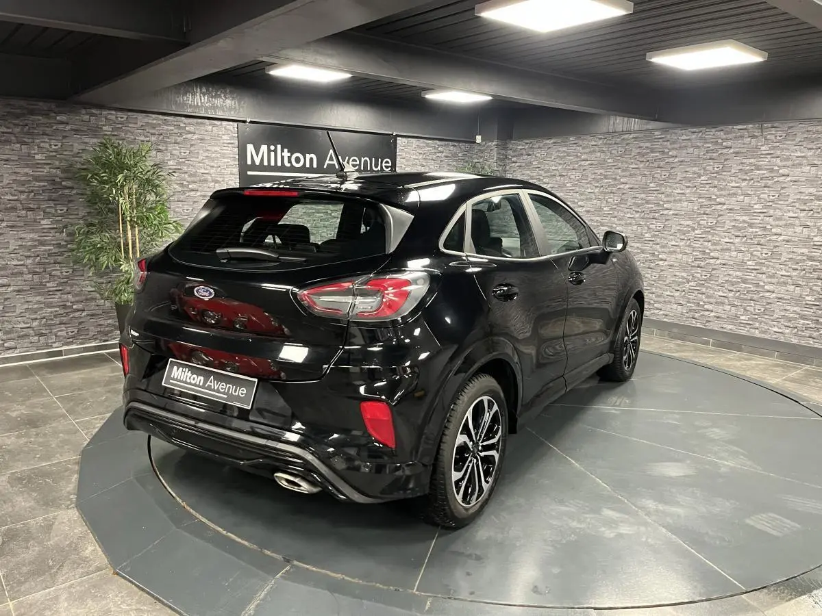 Vue 3/4 arrière droite du Ford Puma noir métallisé avec jantes alliage noires et sorties d'échappement chromées.