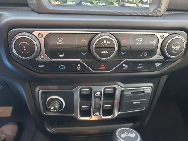 Tableau de bord noir du Jeep Wrangler 2021 avec commandes climatisation et boutons multifonctions en gros plan.