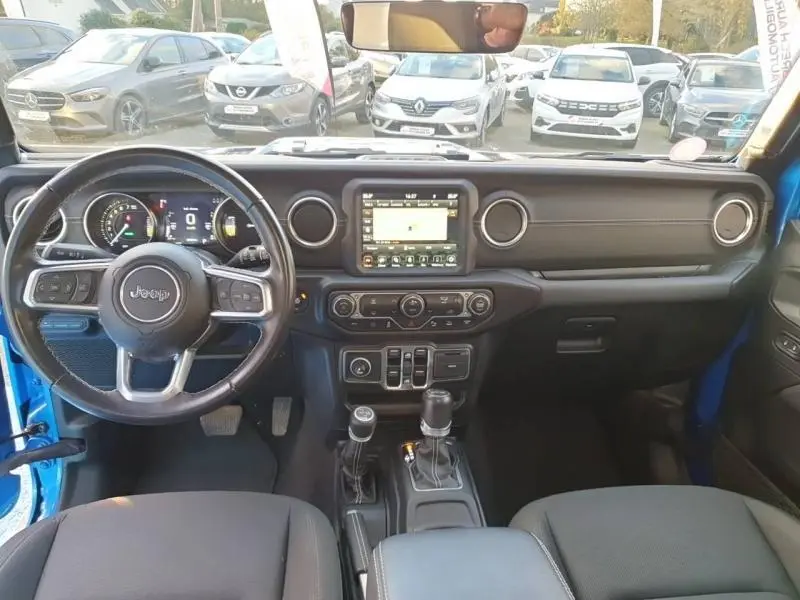 Intérieur avant de la Jeep Wrangler Hydro Blue 2021, tableau de bord noir avec écran tactile et volant cuir multifonction.