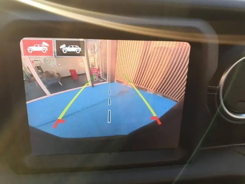Image de la caméra de recul affichée sur l'écran intérieur du Jeep Wrangler Hydro Blue, montrant une zone de stationnement bleue.