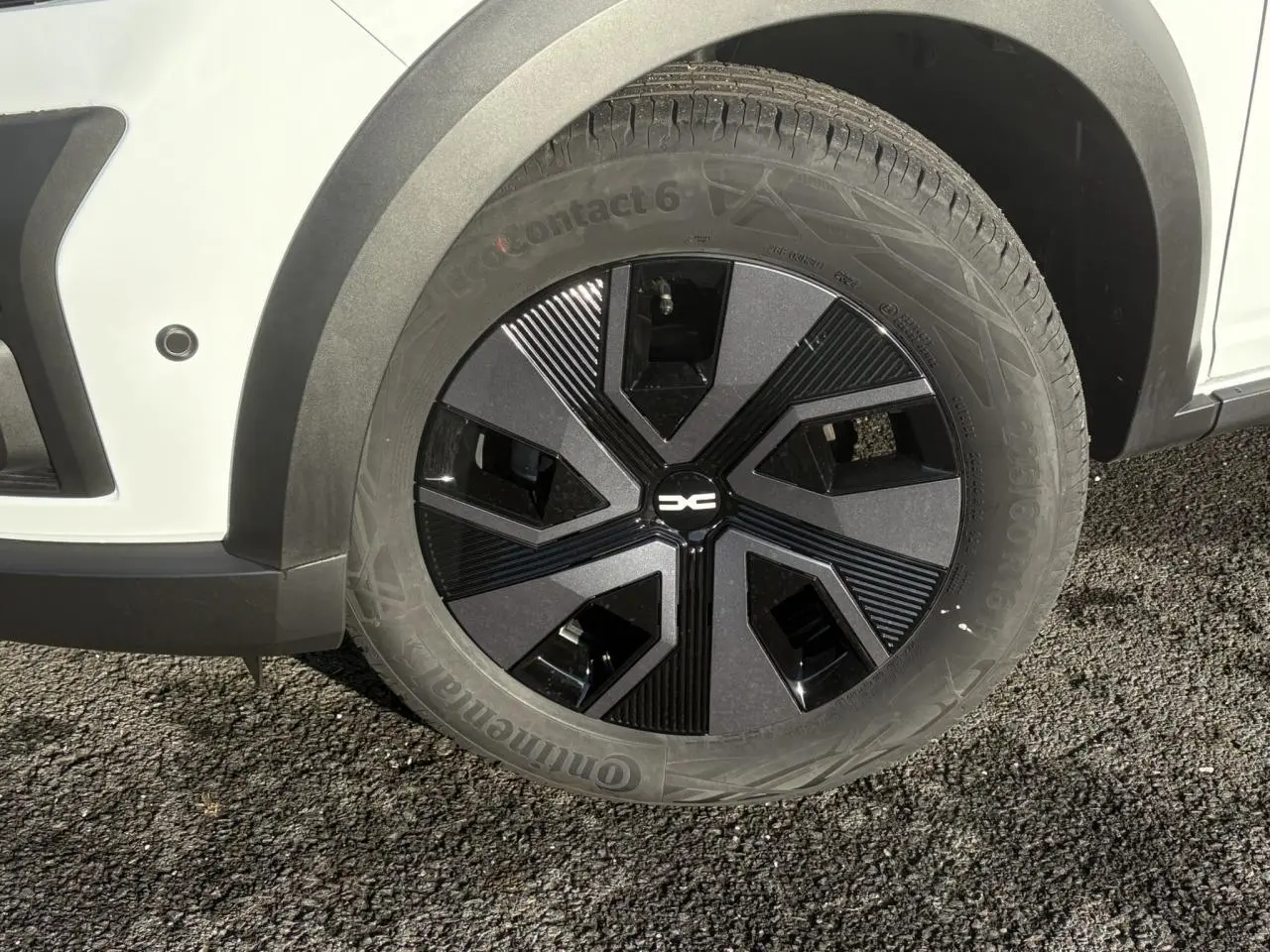 Gros plan sur la roue avant gauche noire et grise du Dacia Sandero Stepway Blanc Glacier 2024 avec capteur de stationnement.