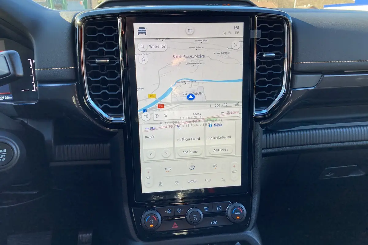 Vue rapprochée du tableau de bord noir du Ford Ranger 2025 avec écran tactile GPS vertical et commandes climatisation.