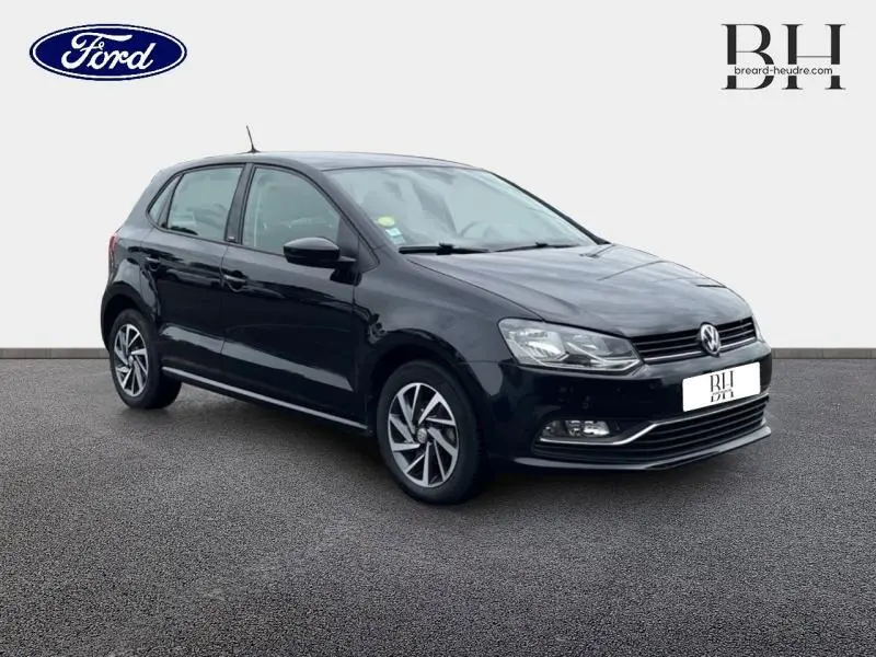 Volkswagen Polo 1.4 TDI noire vue en 3/4 avant droit, avec jantes alliage et phares halogènes allumés.