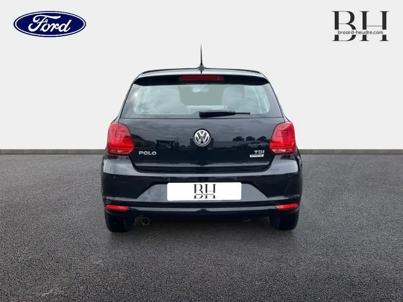 Vue arrière d'une Volkswagen Polo noire unie de 2017 avec feux rouges et logo VW bien visibles.